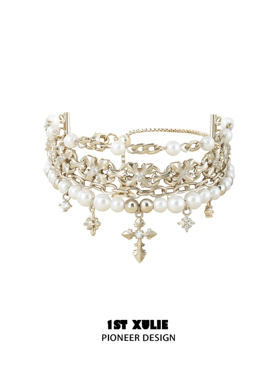 Layered gold-toned bracelet with white pearl beads and hanging fleur-de-lis charms