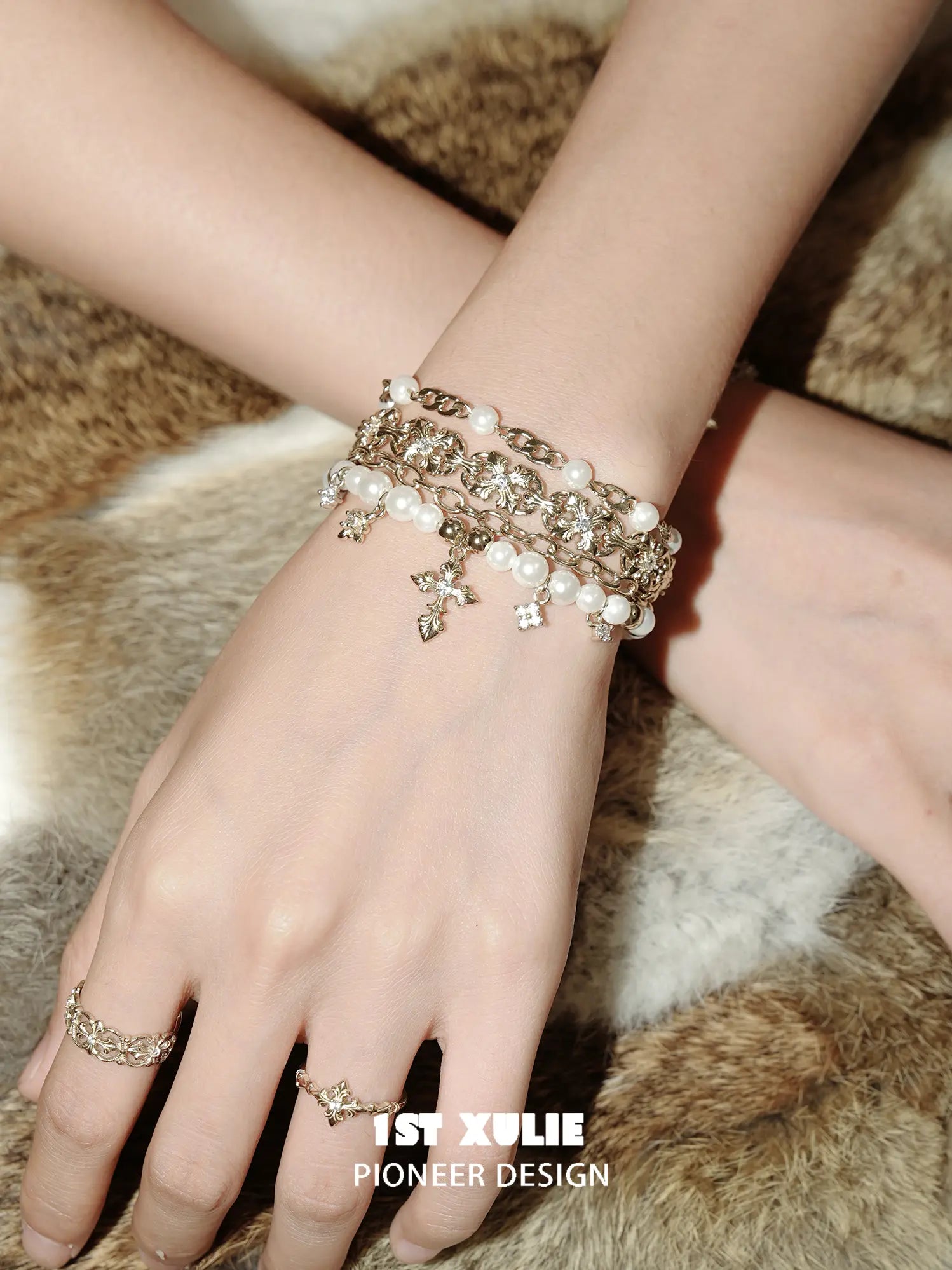 Close view of the bracelet chains, white beads and small hanging charms