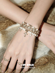 Close view of the bracelet chains, white beads and small hanging charms