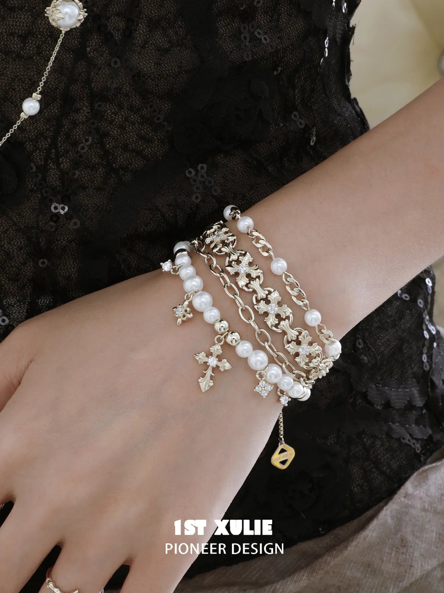 Gold-toned charm bracelet styled against black lace