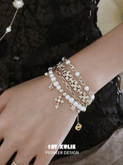 Gold-toned charm bracelet styled against black lace