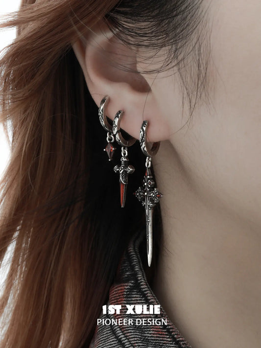 Three red-accented gothic hoop styles worn together on the ear