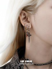 Red drop and dagger hoop earrings worn together on the ear