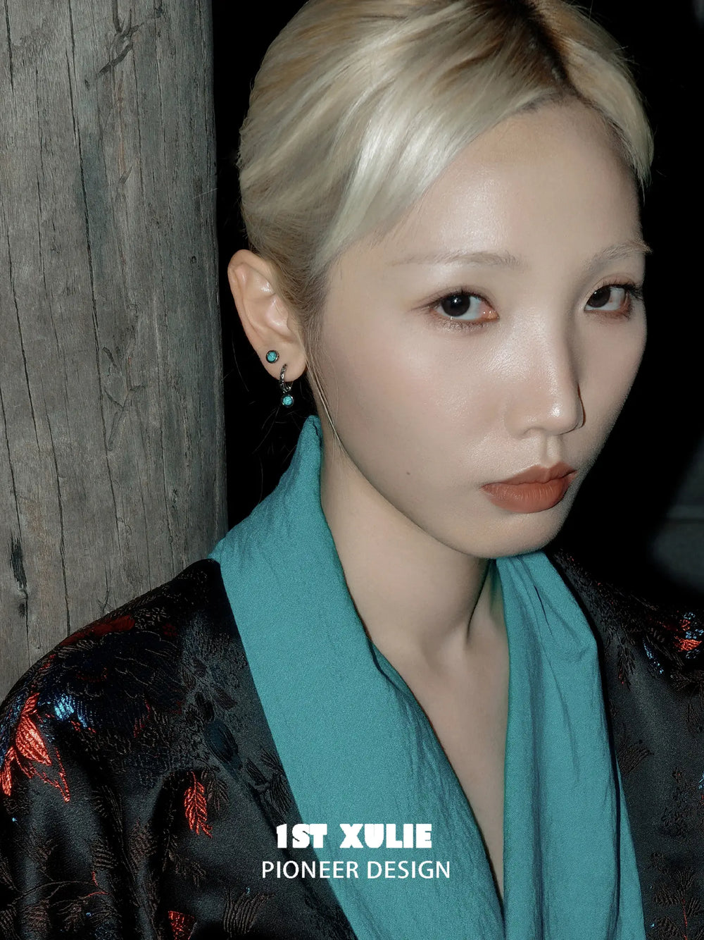 Round composite turquoise hoop and stud earrings worn on the ear