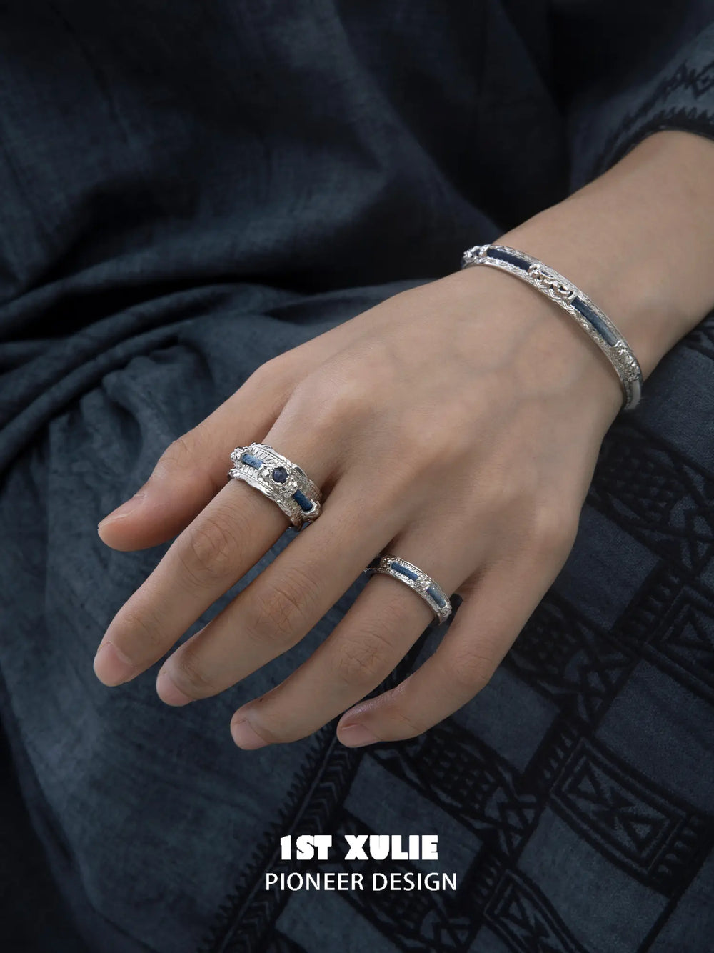 Wide blue woven open ring worn with coordinating jewelry